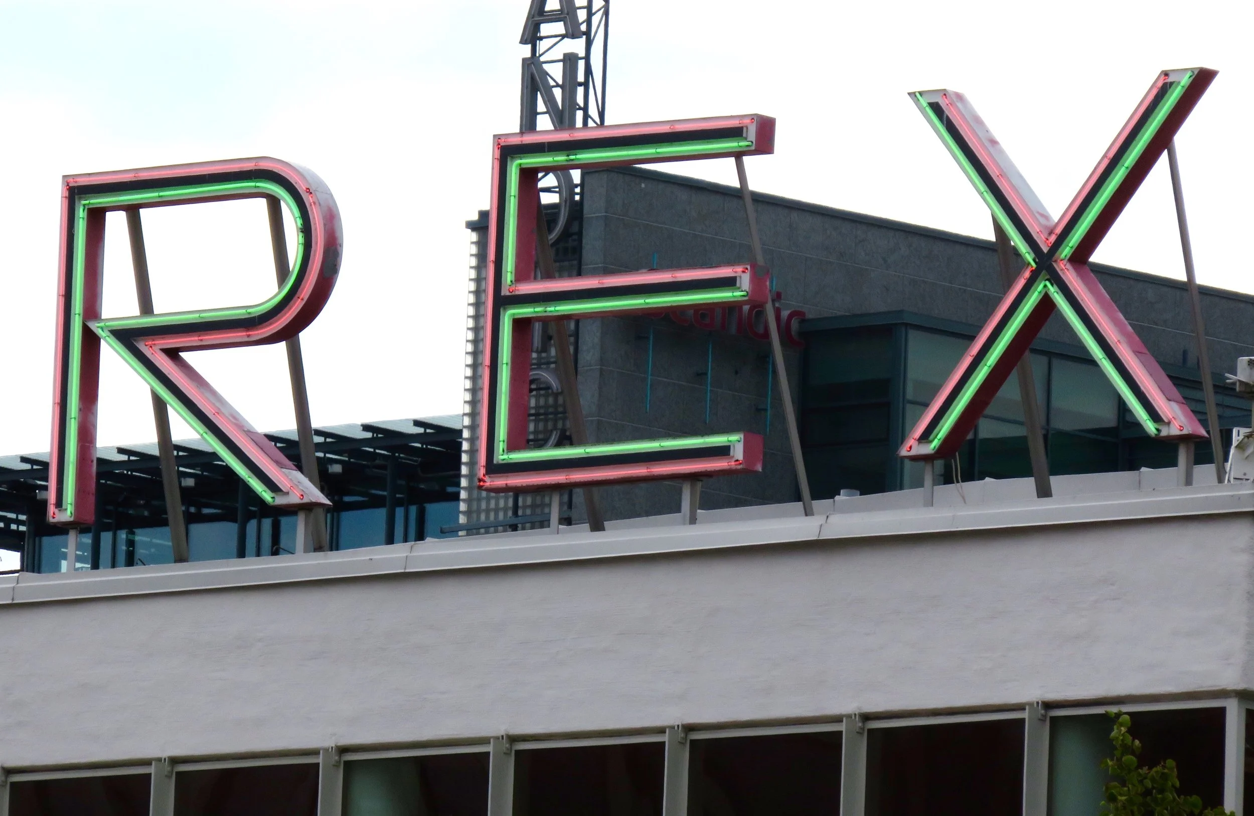 Close-up of the Bio Rex sign, showing the surprisingly intricate combination of red and green neon on red metal backing.