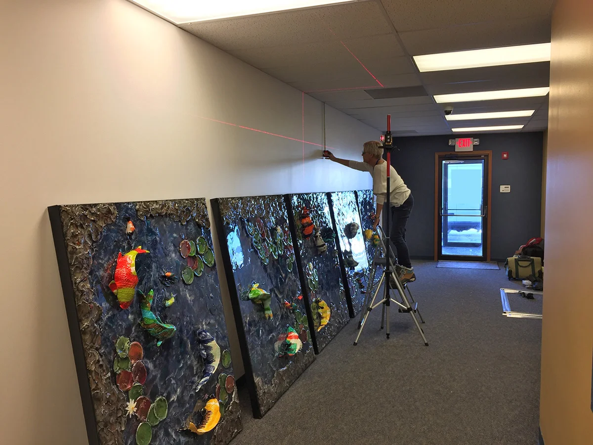 Diana Ahrens adjusting the laser guides for the installation of Magical Pond