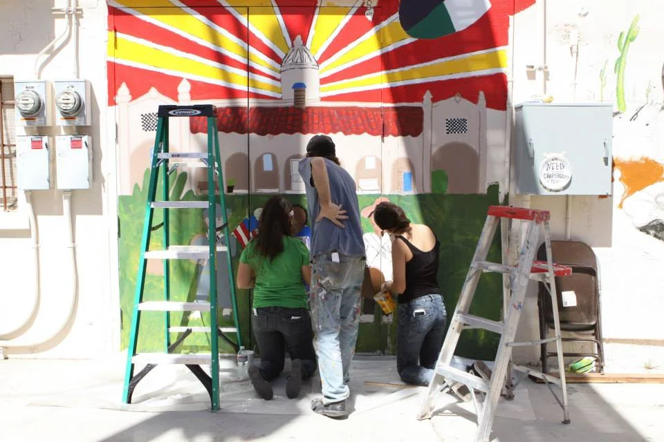 Muralist Michael Schwartz works with Ajo students during the 2015 Street Art Gathering