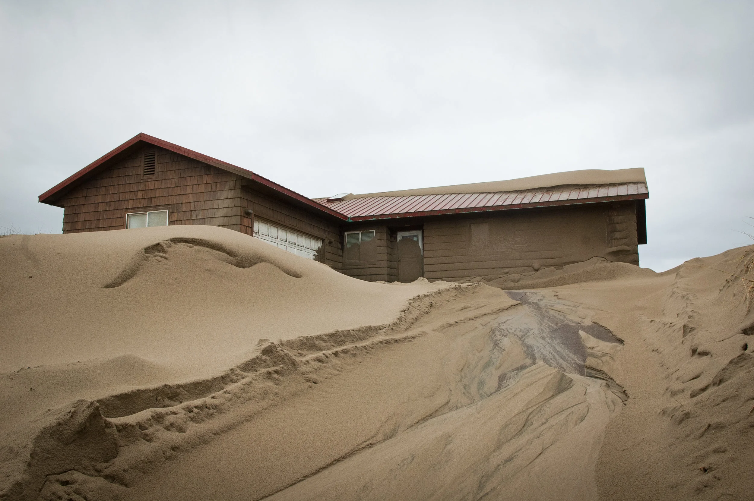 Sand has encroached on houses in Waldport, OR for decades, causing constant headaches for owners.