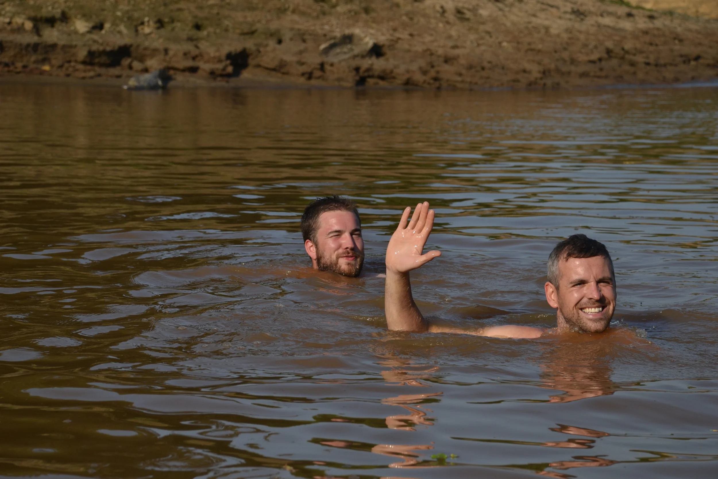 Swimming in search of Pink river dolphins. Spot the Caiman on the bank. Another has just slunk into the water. 