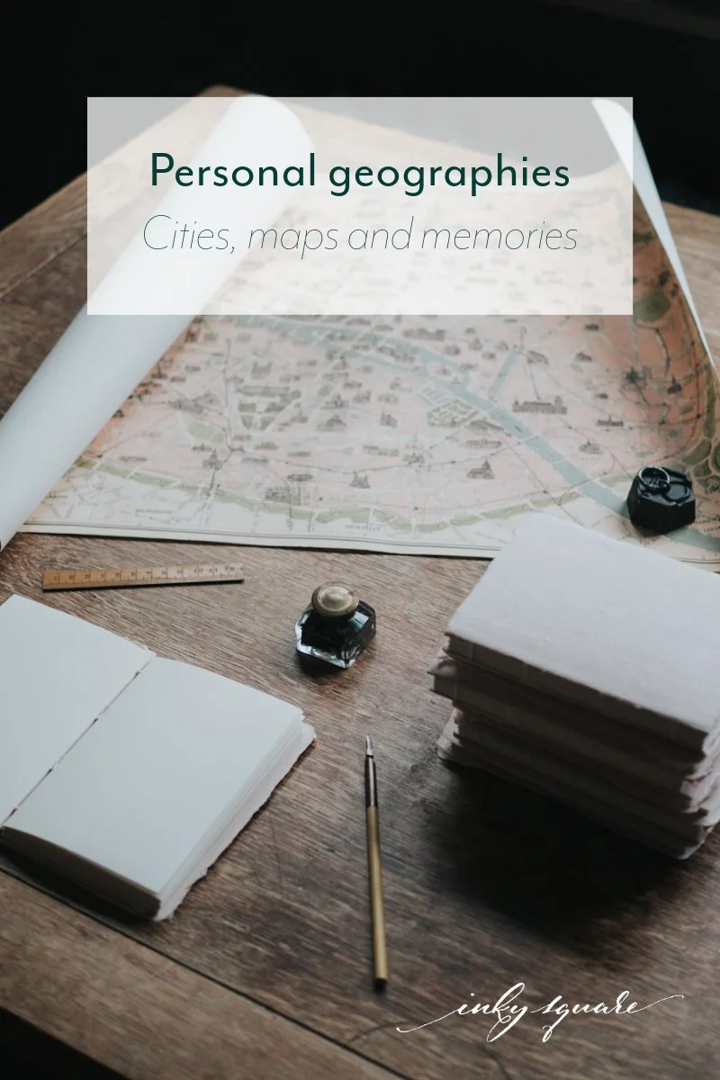Open notebook, pile of notebooks, map, pen, ink bottle and ruler on a table and the text 'Personal geographies: cities, maps and memories'