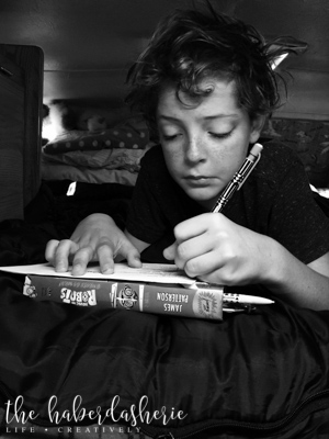 sometimes trips involve homework! 'noir' filter, taken at his level.