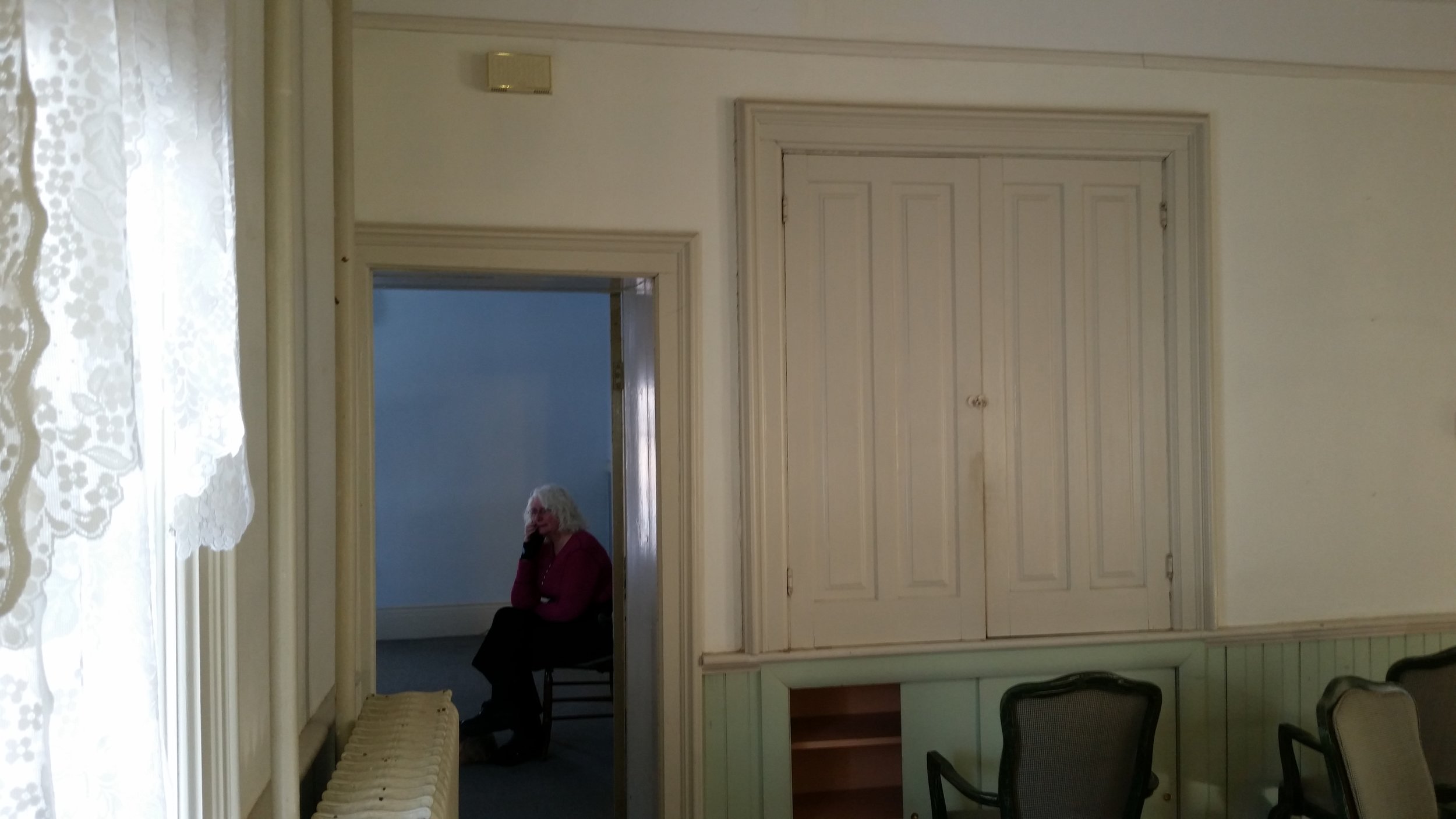 Here is the original wall with a door to what became the library. The door jamb was about 18 inches wide and set at an angle. The lower section of the cabinet had doors that were plywood. We closed off both the door and the cabinet on the dining room side and used the space to make built in bookshelves in the library. We also removed the hot water radiator when we installed under the floor radiant heat. That's Marti sitting in the library wondering "what are we going to do with this?" 