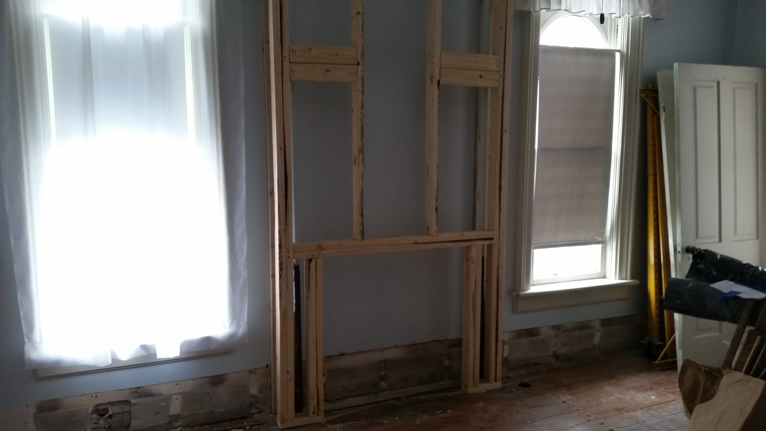 Our built in "entertainment center" also hides the hot water heating pipes needed on the second floor. We custom sized this box to fit an antique mantle which would house our flat screen TV. David's measurements were great for the final installation... but he couldn't get the TV thru the opening with the mantle installed. He had to unscrew the mantle and slide it in from the side. If it ever stops working it'll be coming out in pieces or we get to disconnect the electrical lights and remount the mantle again. The fun just never ends!