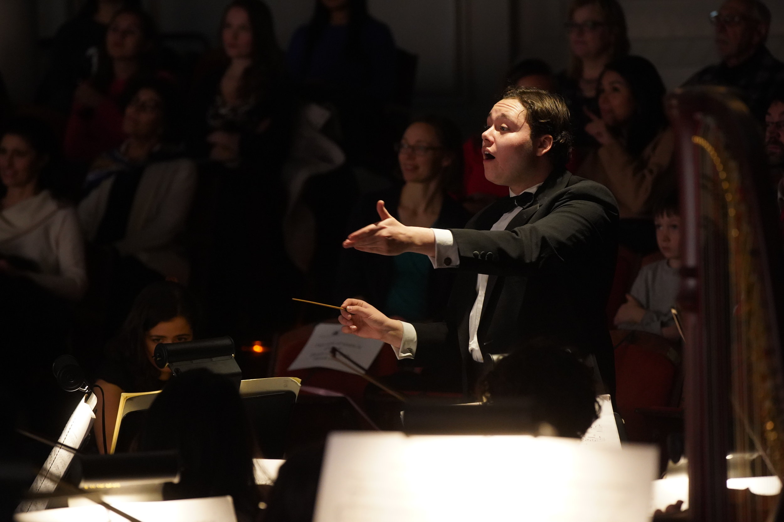  Benjamin P. Wenzelberg conducts the Harvard College Opera orchestra in Massenet’s  Cendrillon . Photo: Charles Wenzelberg. 
