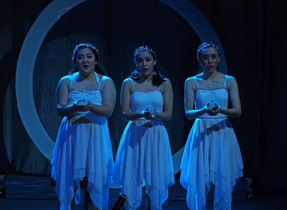  Act II: Three child-spirits (Sydney Penny ’22, Katharine Courtemanche ’21, and Olympia Hatzilambrou ’23) prophesy the rising of the sun and ending of the night, representing a triumph of wisdom over superstition, a reuniting of Earth and Heaven, and