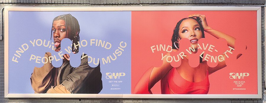A side-by-side billboard featuring a young man with dreadlocks on the left and a young woman with dreadlocks on the right. The background colors are blue on the left and red on the right. The billboard promotes using an app to find people, music, and your wave length.