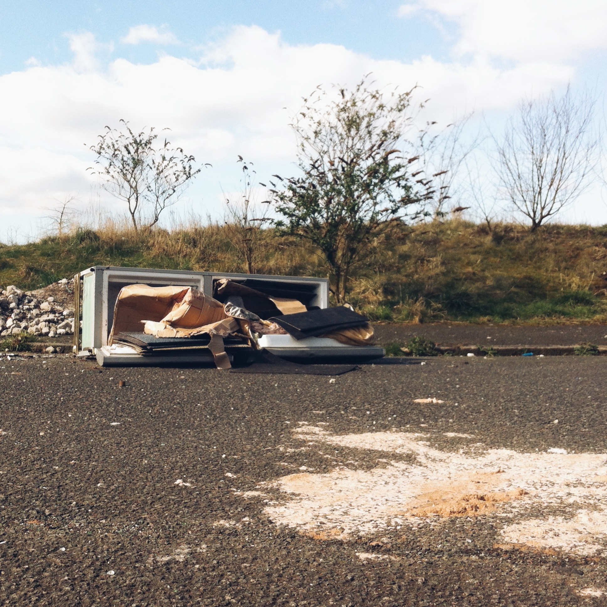 Fridge full of junk on the side of the road.