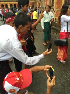 Local tourists: Myanmar men and boys take photos on their smartphones at the Secretariat in Yangon. Source: Ronda Zelezny-Green
