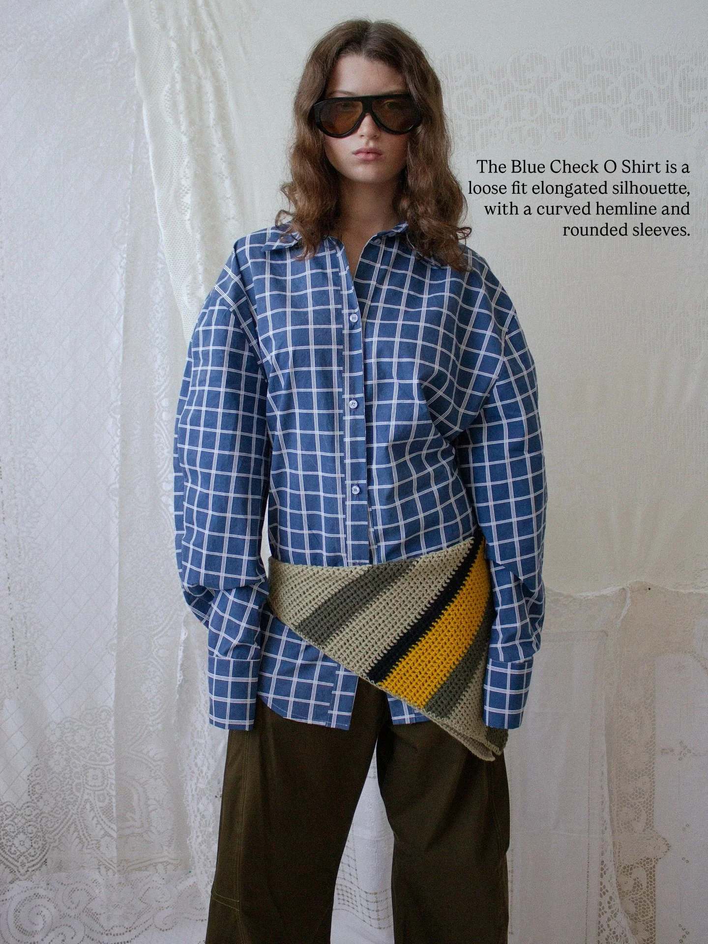 Guys it is now day 5 of revealing designs from our collection, and today we are looking at the Blue Check O Shirt and the Khaki Barrel Trousers.

The Blue Check O Shirt is a loose fit elongated silhouette, with a curved hemline and rounded sleeves. I