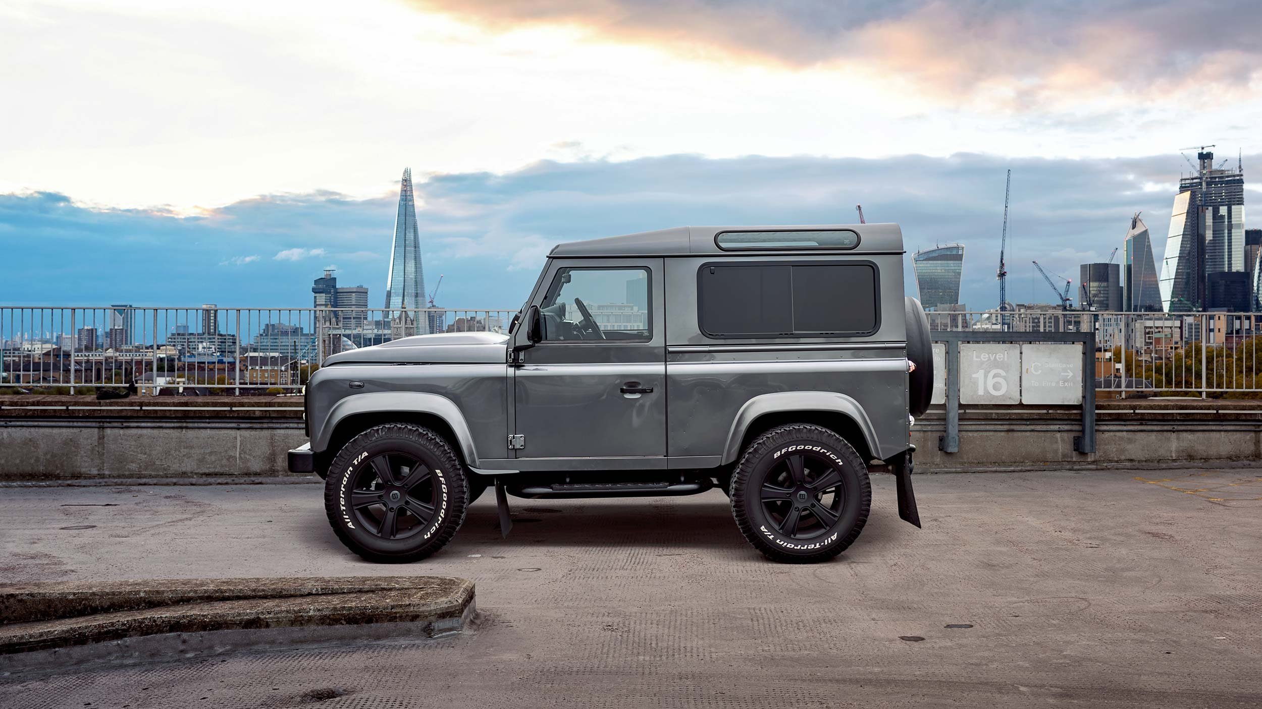 Grey bespoke Defender 90 in side profile with the Shard and City of London skyline visible in the distance.
