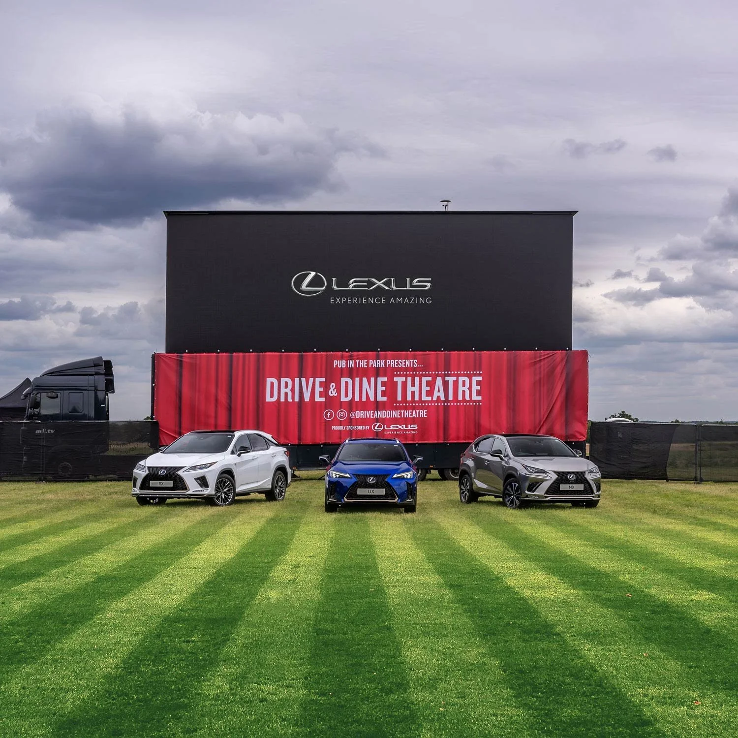 Lexus Drive & Dine Theatre brand activation event with RX, UX and NX models on grass in front of large screen – automotive events photography London