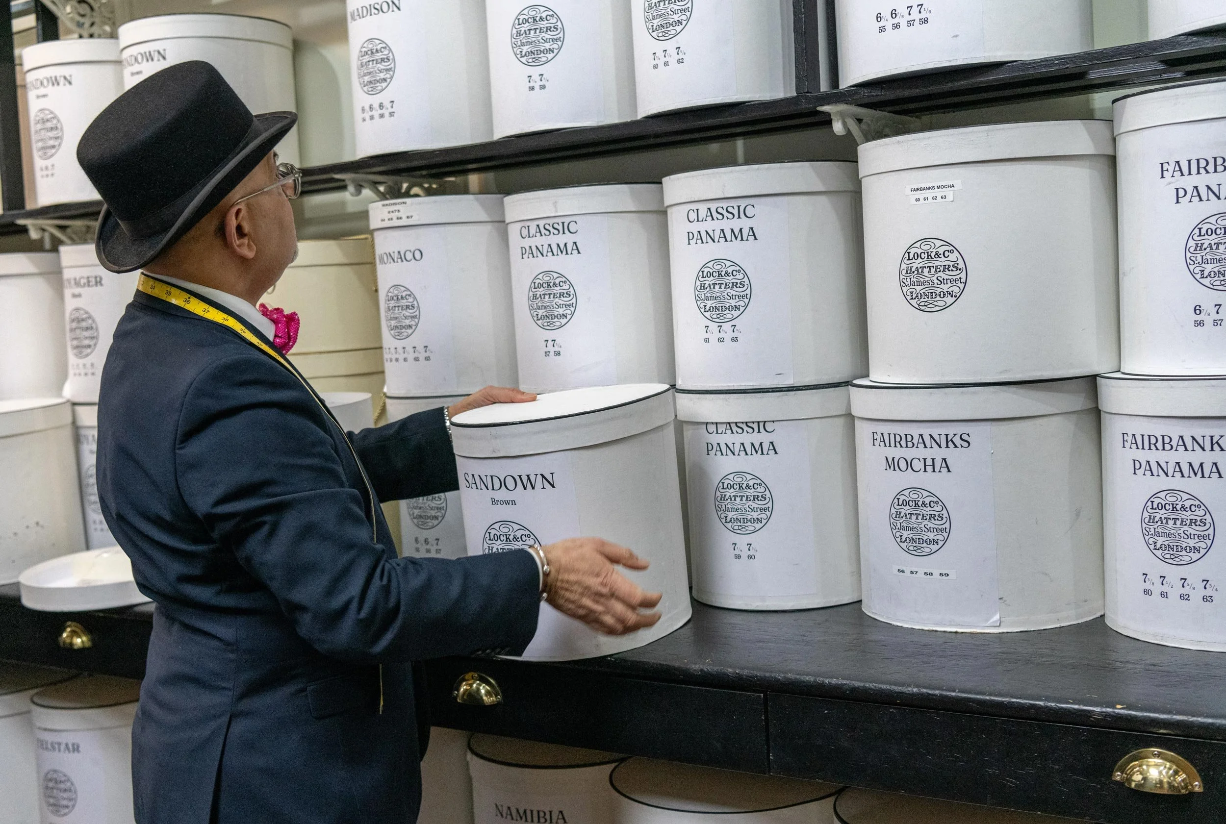 Lock & Co. Hatters employee amongst traditional hat boxes during the Wear A Hat Day event in London.