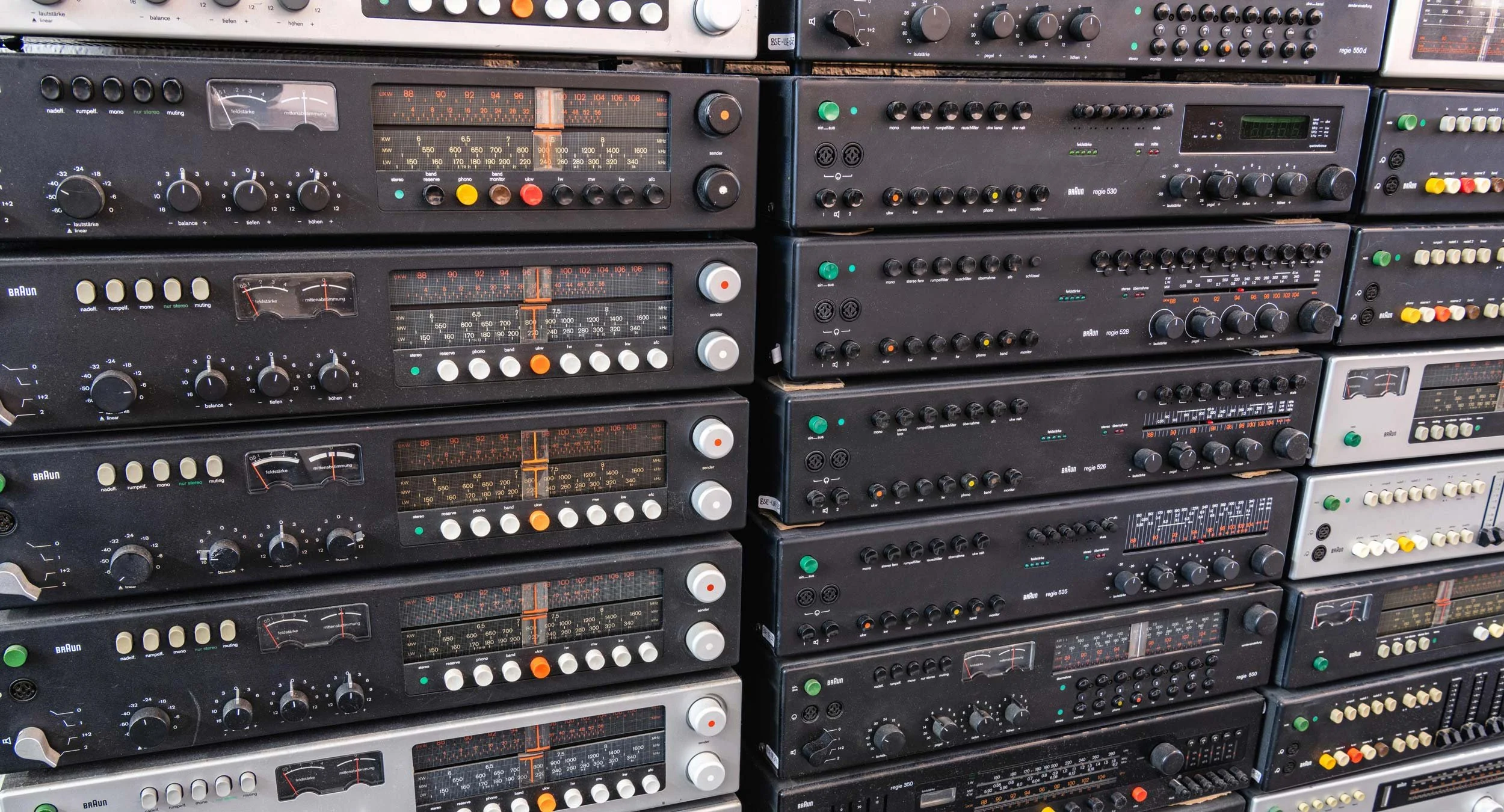 Close-up of vintage Braun audio equipment showing tuning scales, control knobs and coloured buttons.