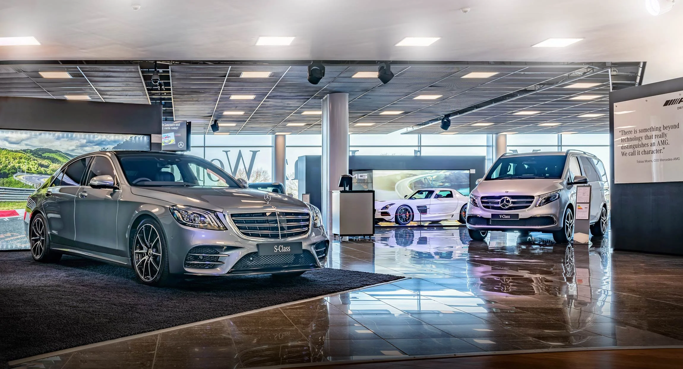 Modern luxury Mercedes dealership showroom in London with grey S-Class and silver V-Class on polished floors – premium showroom photography