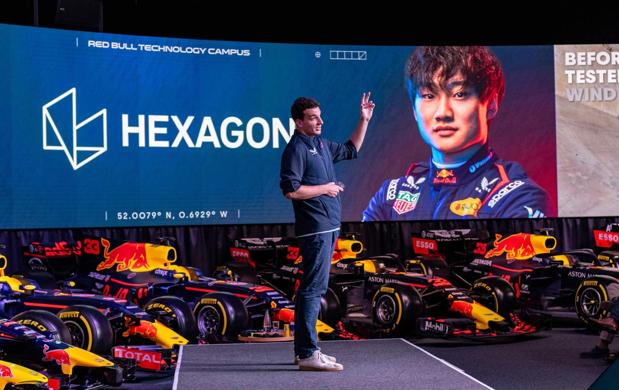 London event photographer – Speaker presenting on stage at Oracle Red Bull Racing MK-7 with F1 cars in background