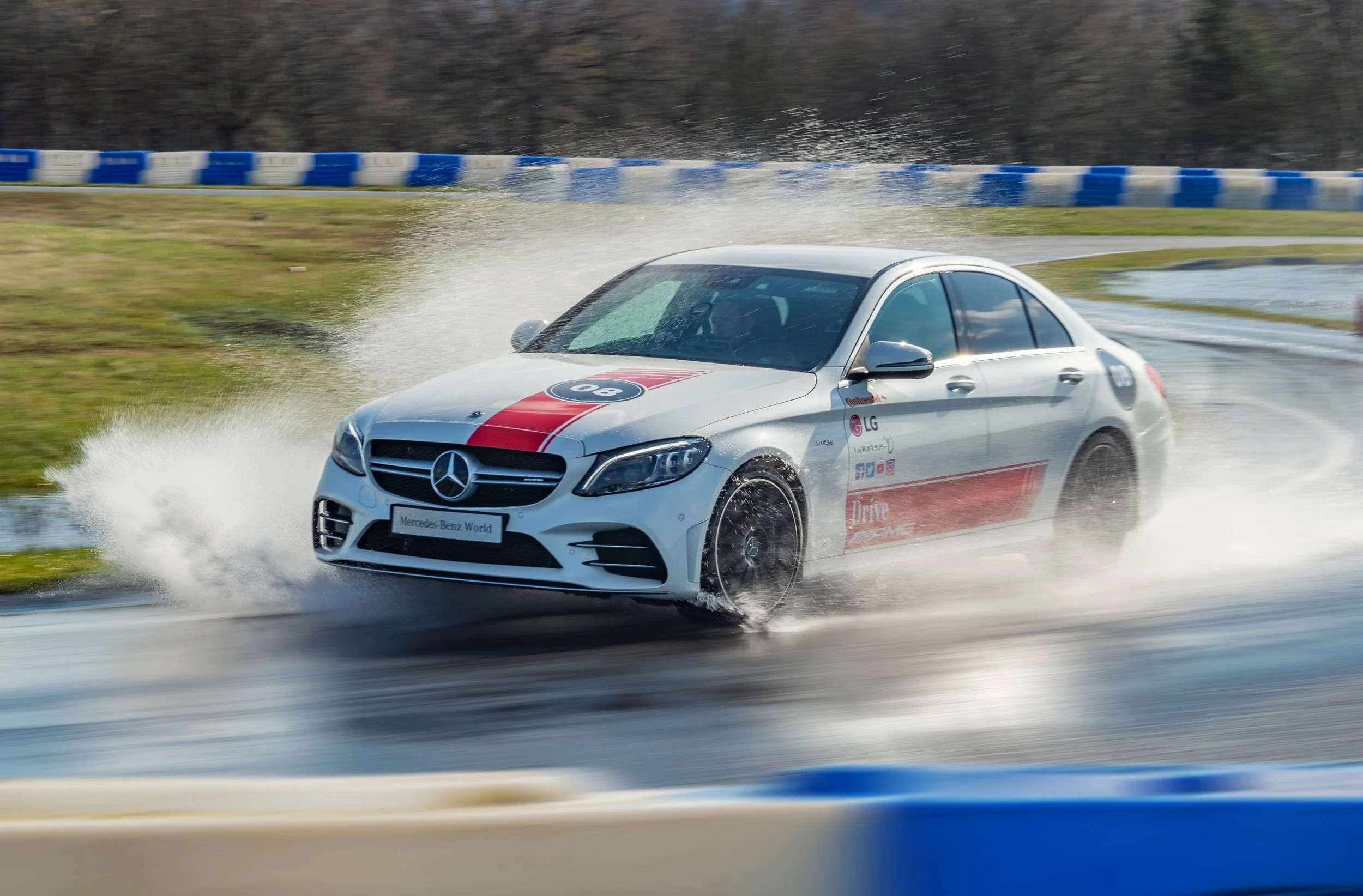 White Mercedes-AMG C-Class on the wet circuit at Mercedes-Benz World, Brooklands