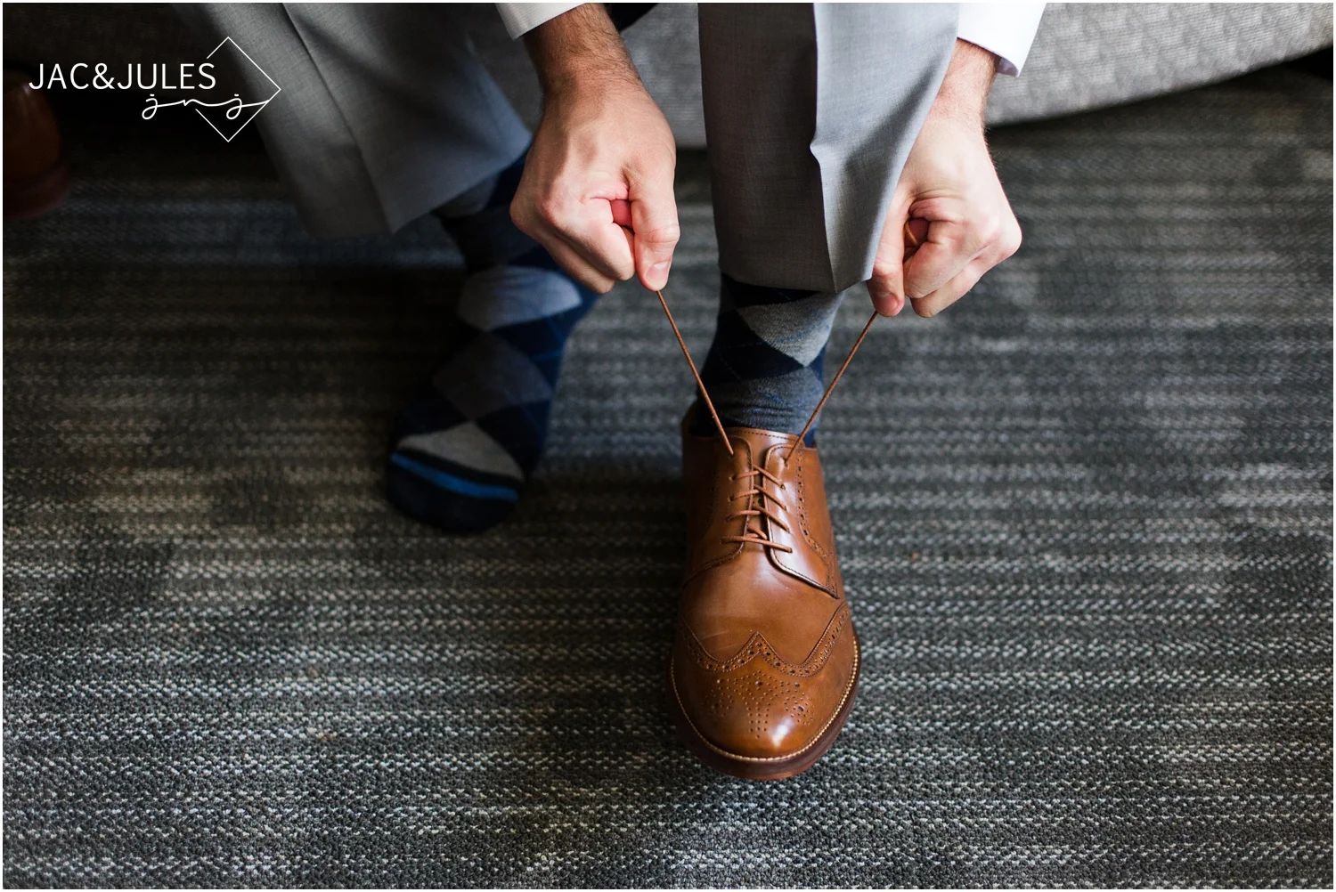 Groom tying his shoes at Courtyard Marriott in Wall, NJ