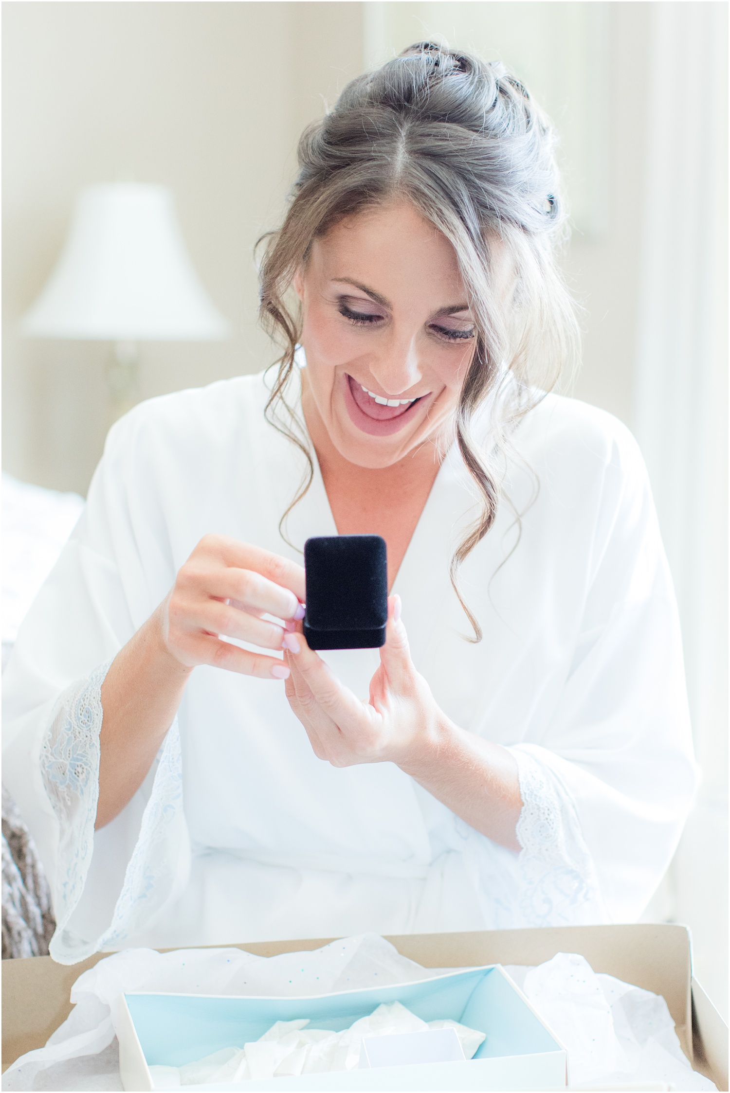 Bride opening a gift from her groom while getting ready in Brick, NJ.