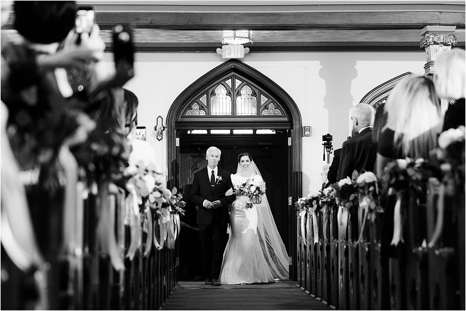 father walks bride down the aisle at church wedding ceremony
