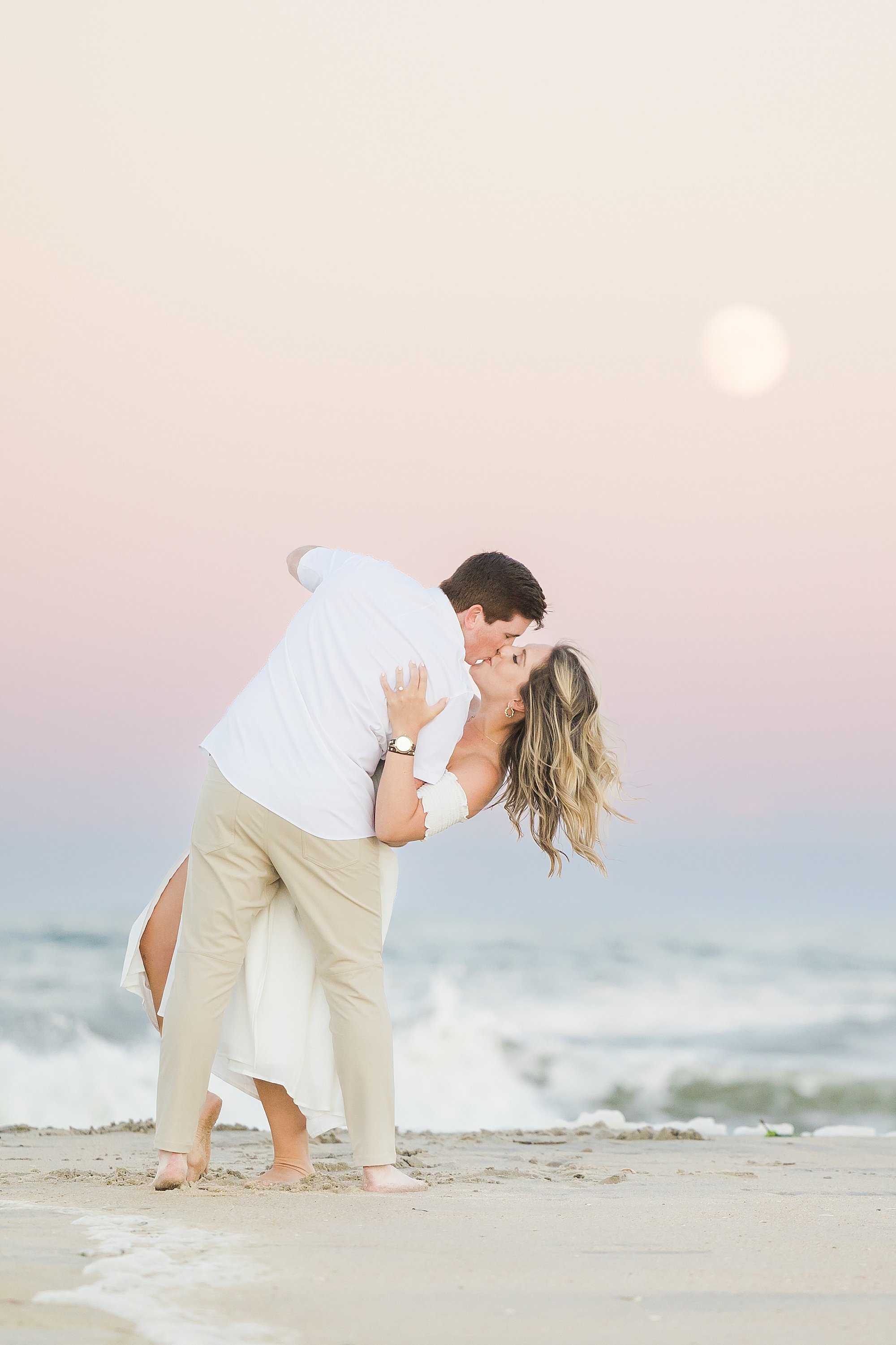 engagement photos at sunset of a couple kissing on the beach
