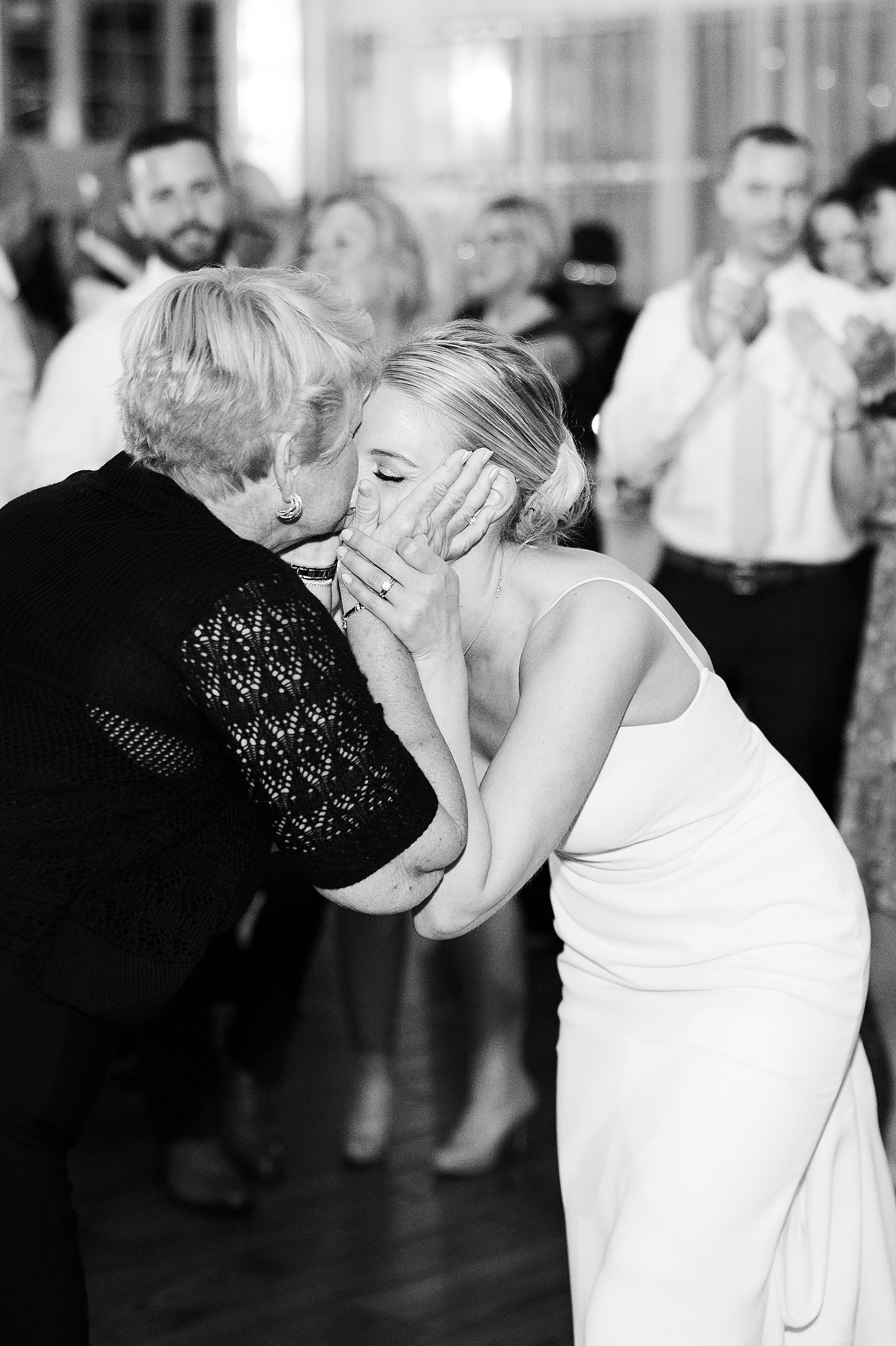 grandma kisses granddaughters forehead at Liberty House wedding reception