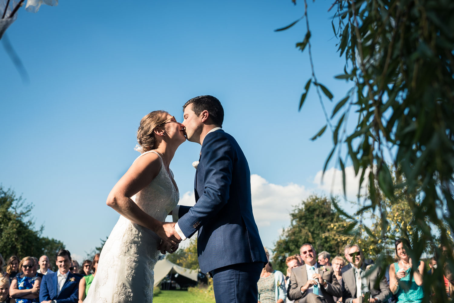 de kus tijdens ceremonie huwelijk, vastgelegd door trouwfotograaf uit Brabant Cfoto