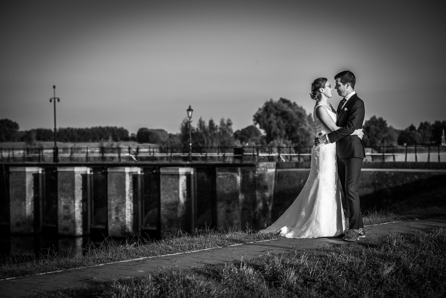 Benedensas, bruidsfotografie, met de fietsbrug op de achtergrond, aan de Steenbergse Vliet