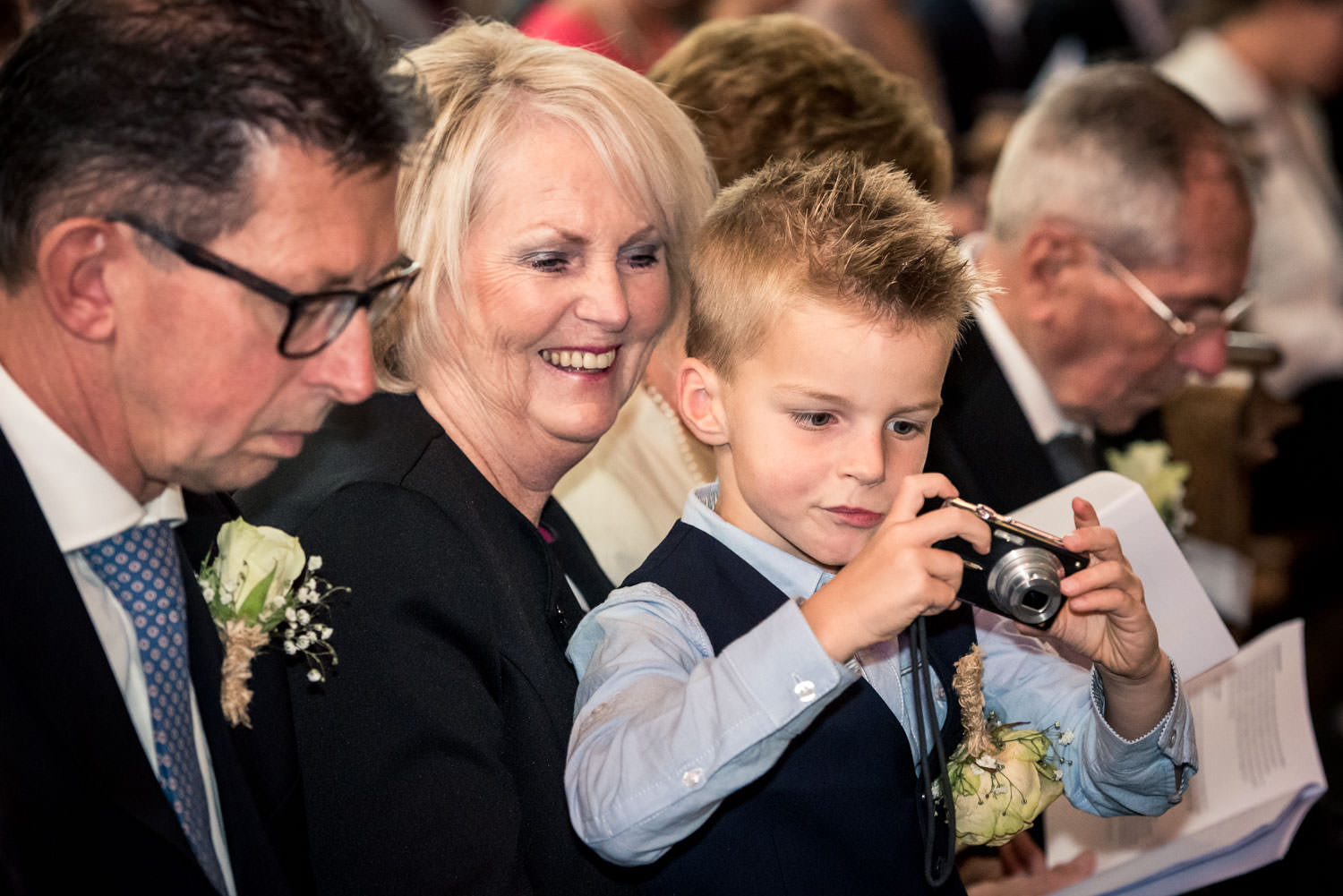 Een bruidsjonkertje maakt een foto tijdens de ceremonie, mooie h