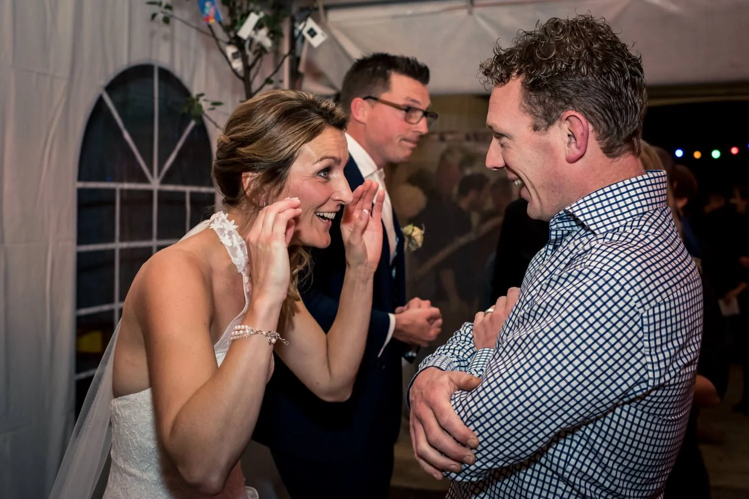 Spontaan moment tijden de felicitatie van de bruid met een gast.