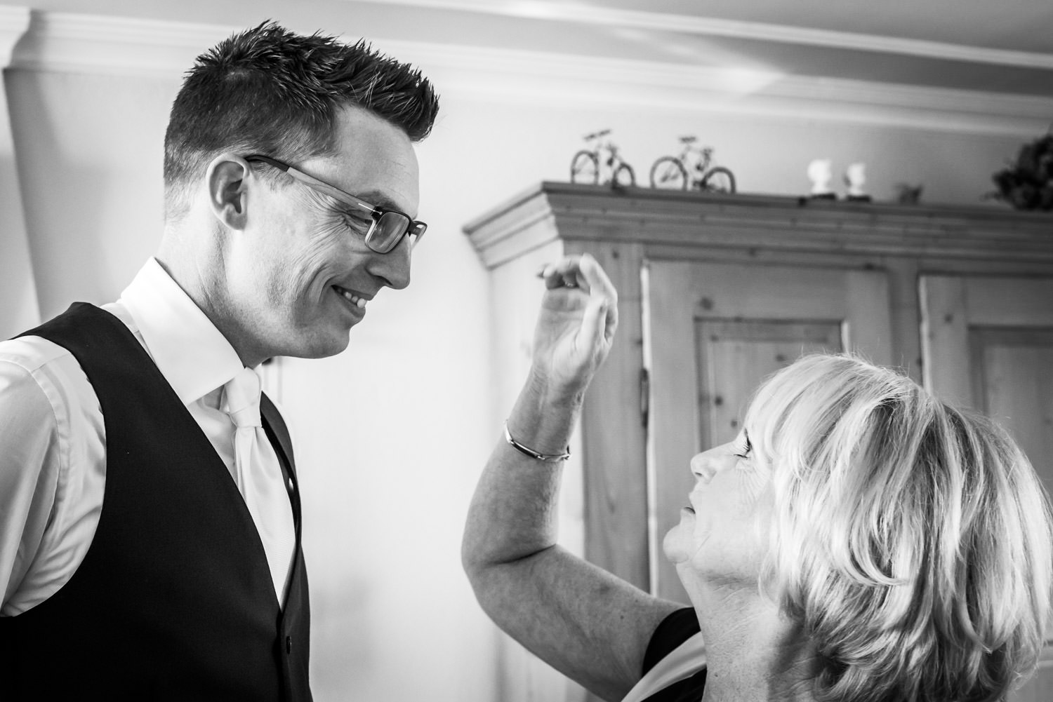 Trouwfotograaf legt vast dat moder het haar van de bruidegom aan