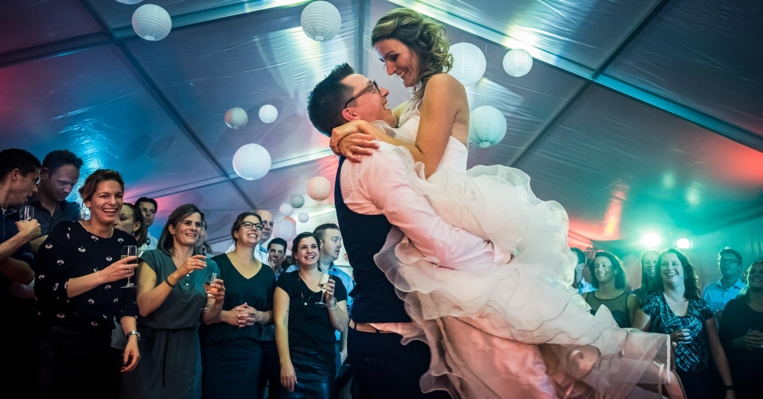 Trouwfotografie bruidspaar met lift bruid tijdens het trouwfeest