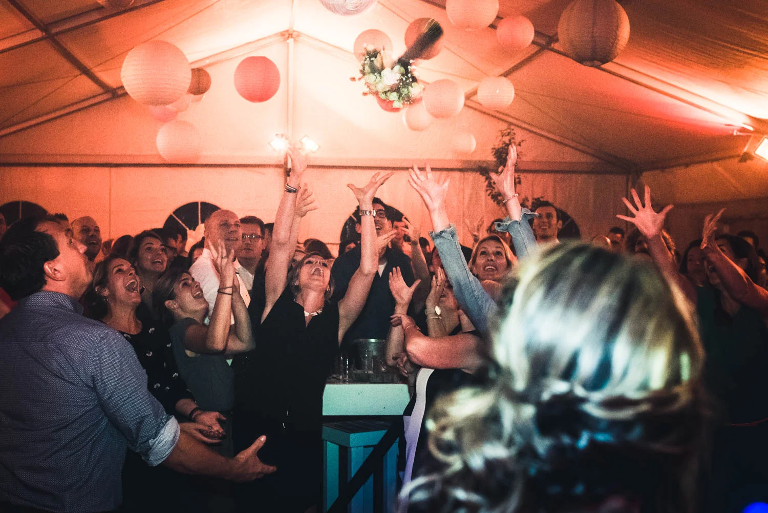 de gasten vangen het boeket tijdens het trouwfeest.