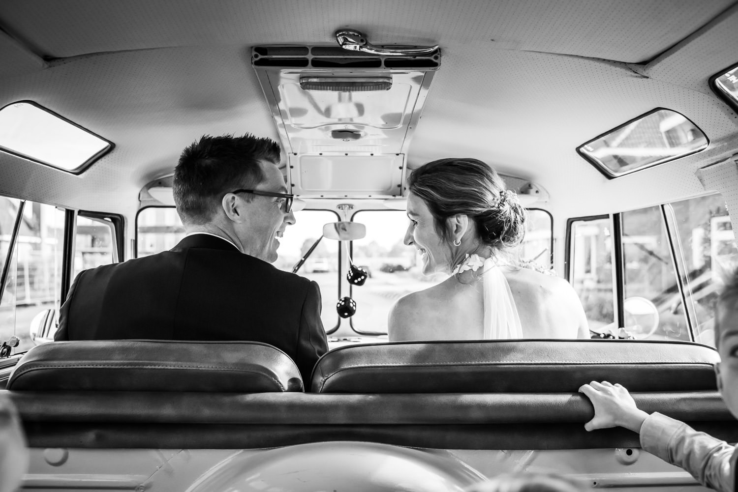 bruidspaar zit in een volkswagenbusje, bruidspaar op weg naar br