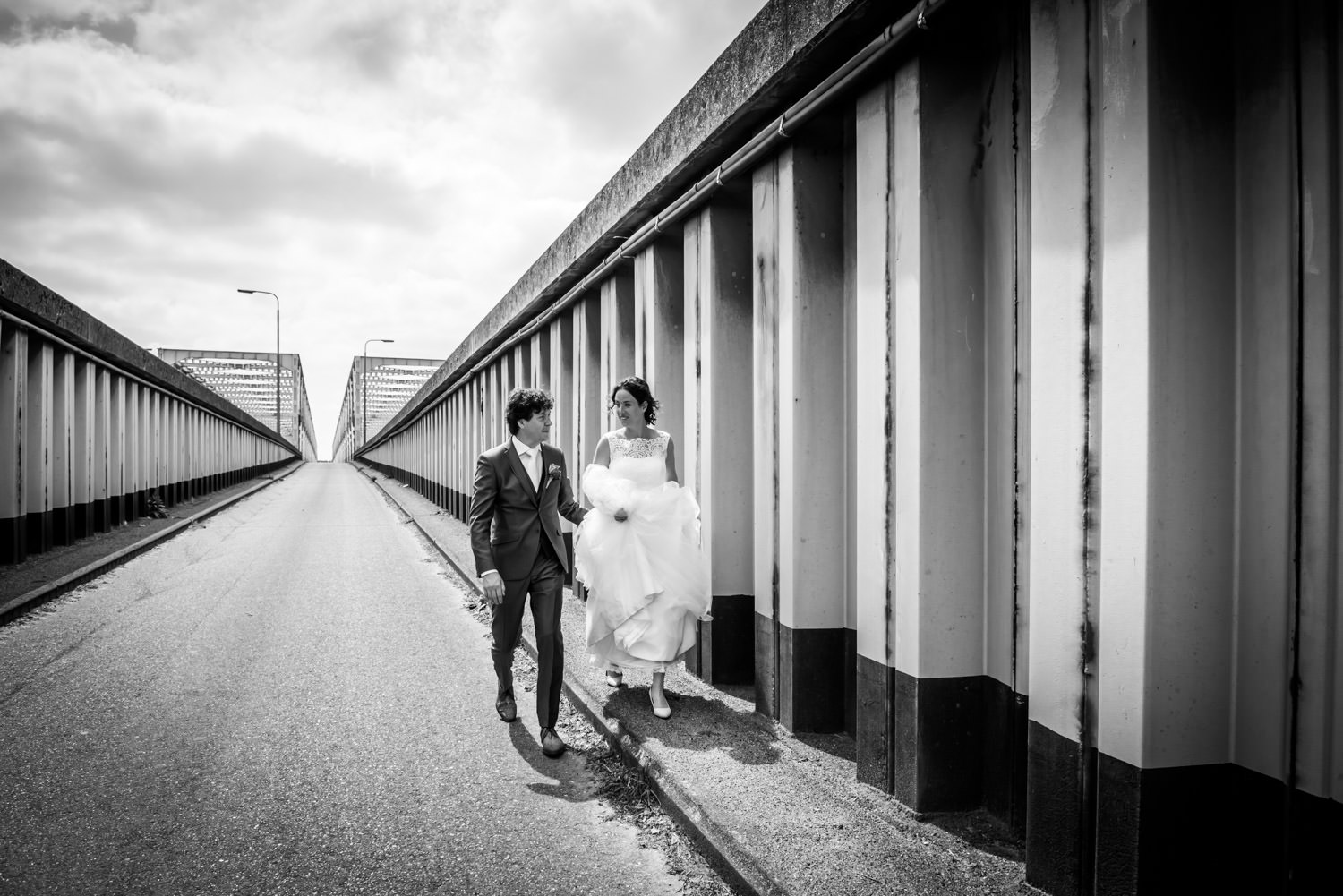 het bruidspaar loopt weg bij de brug van Keizersveer