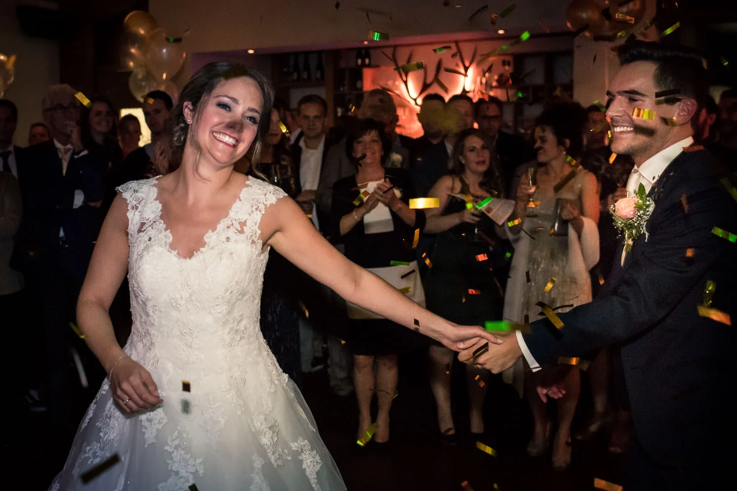Veel lol hebben de bruid en bruidegom om de confetti die losgaat