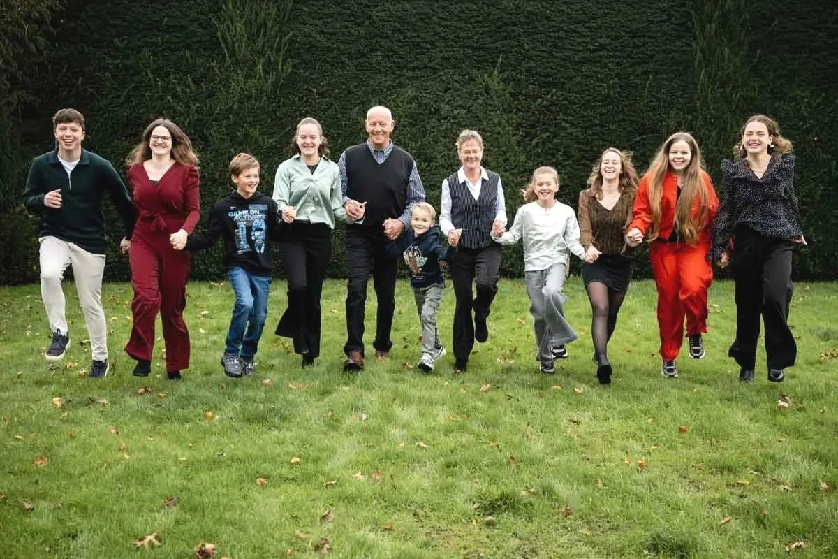  groepsfoto, in spontane setting, opa en oma rennen met al de kleinkinderen. 