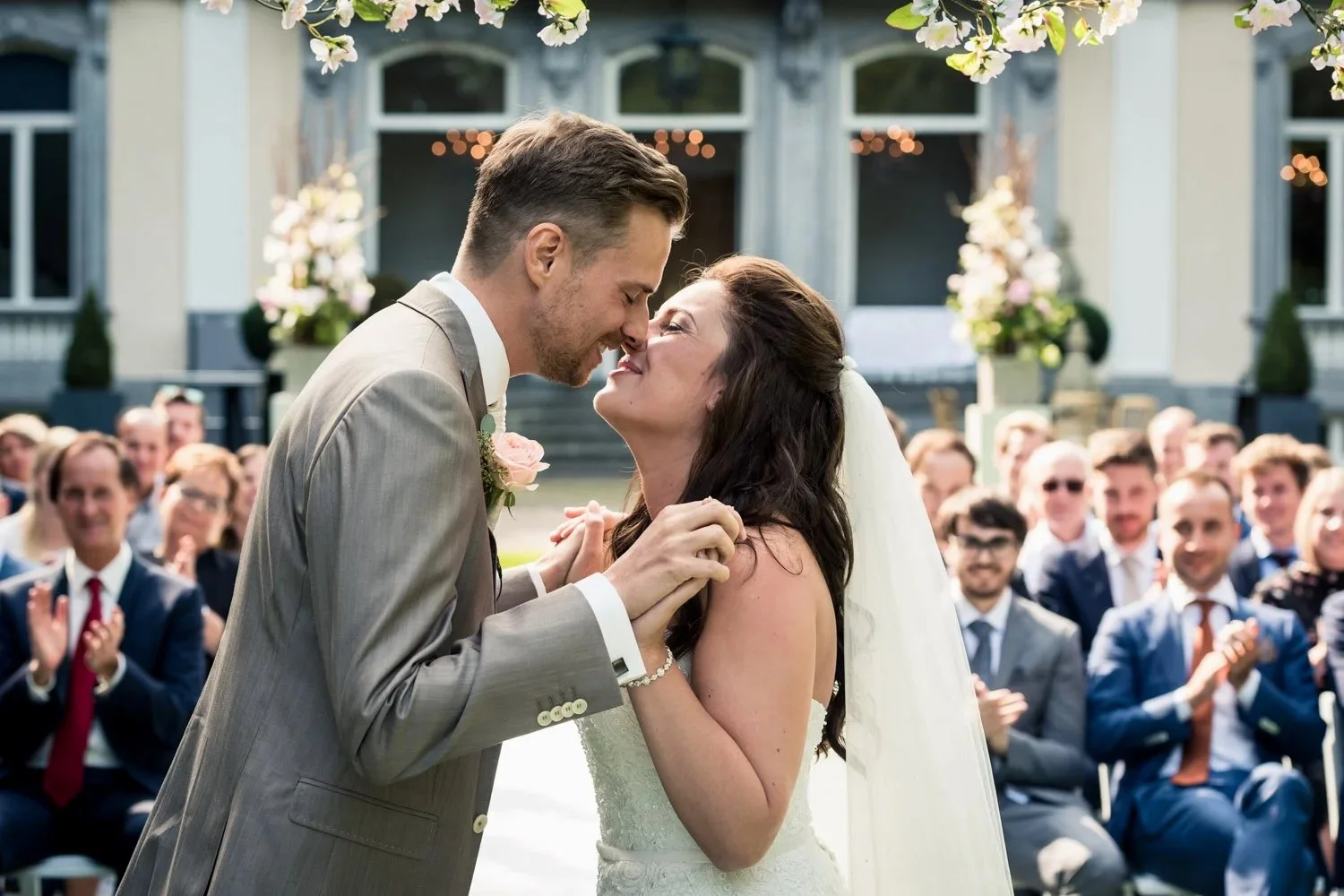 kus na het jawoord tijdens de ceremonie, op landgoed Wolfslaar, omdat het zulk prachtig weer was kon de ceremonie buiten plaatsvinden met het landgoed op de achtergrond.