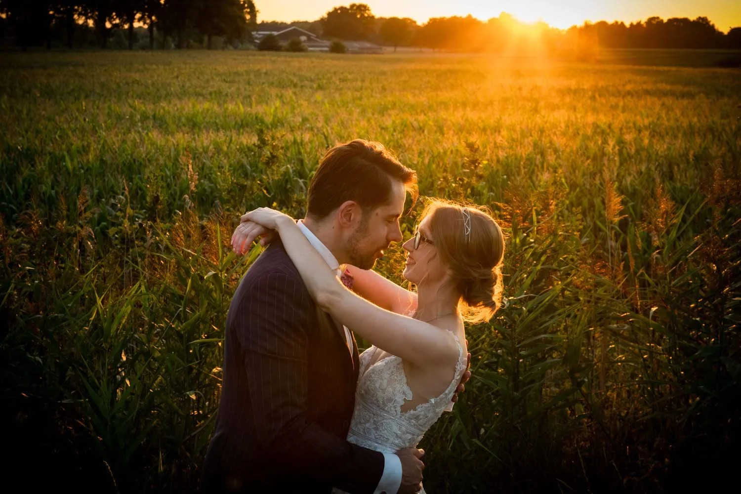 mooie foto van het bruidspaar, trouwfotografie in de avond tijdens gouden uurtje, subdown, prachtig licht. Trouwfotografie