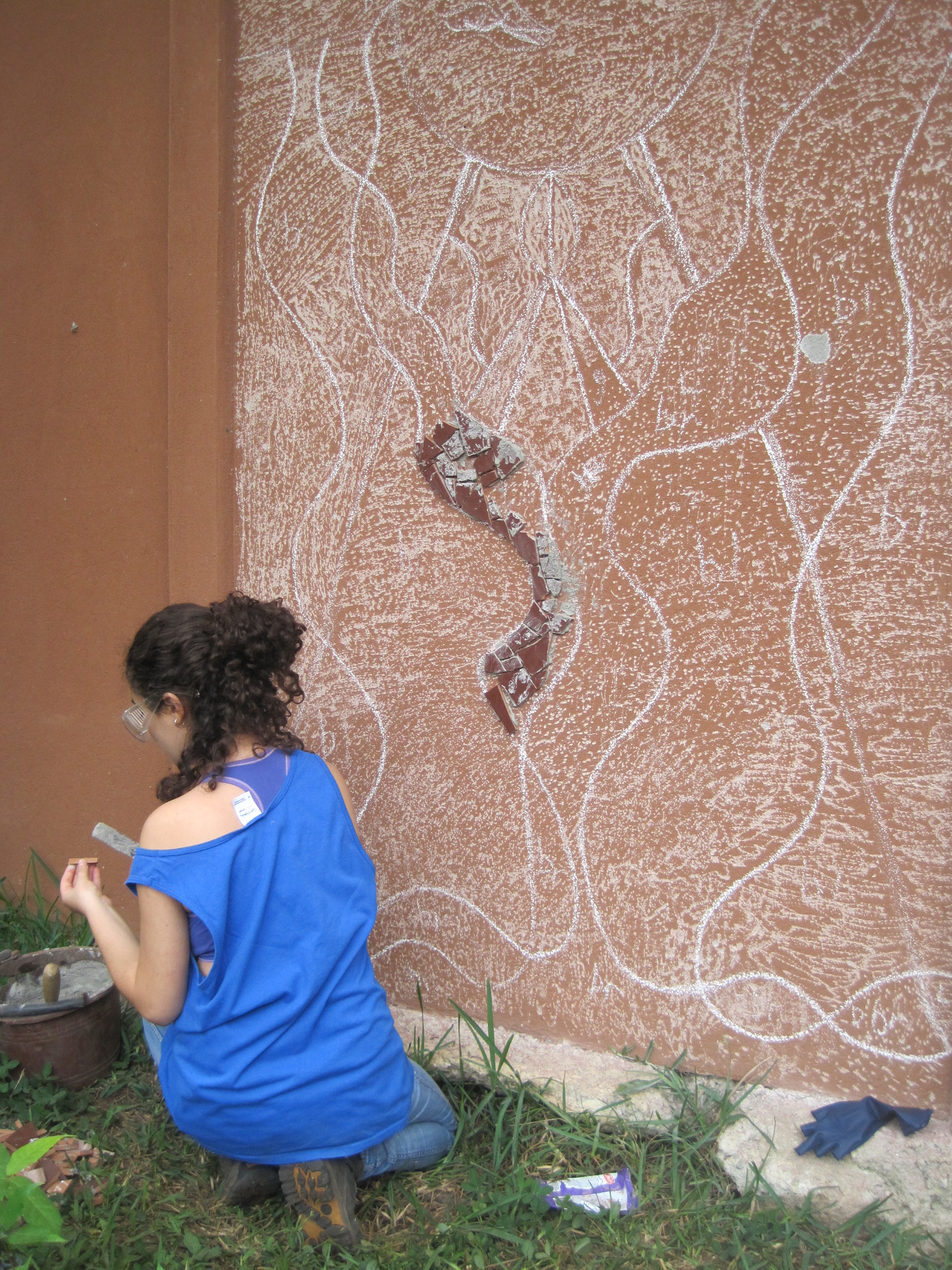  Applying cement to a ceramic piece before placement onto the wall. 