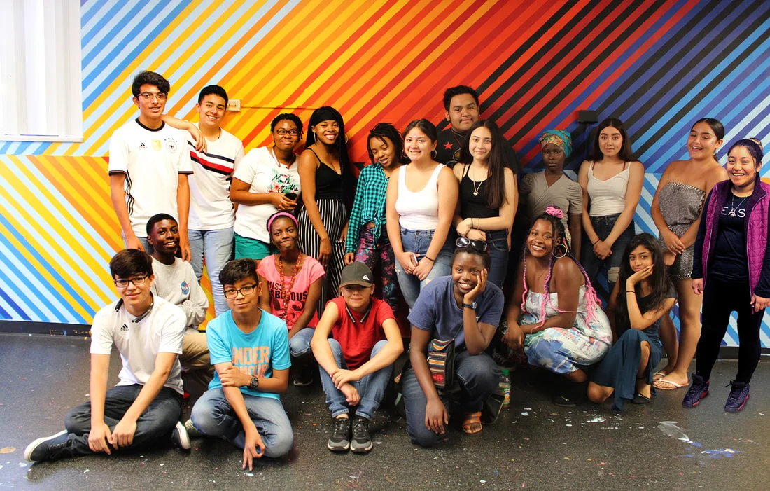 One of several YEA Summer Intern cohorts, posing for the camera in front of a mural they helped create and paint, with member’s of Denver arts organization, Birdseed Collective.