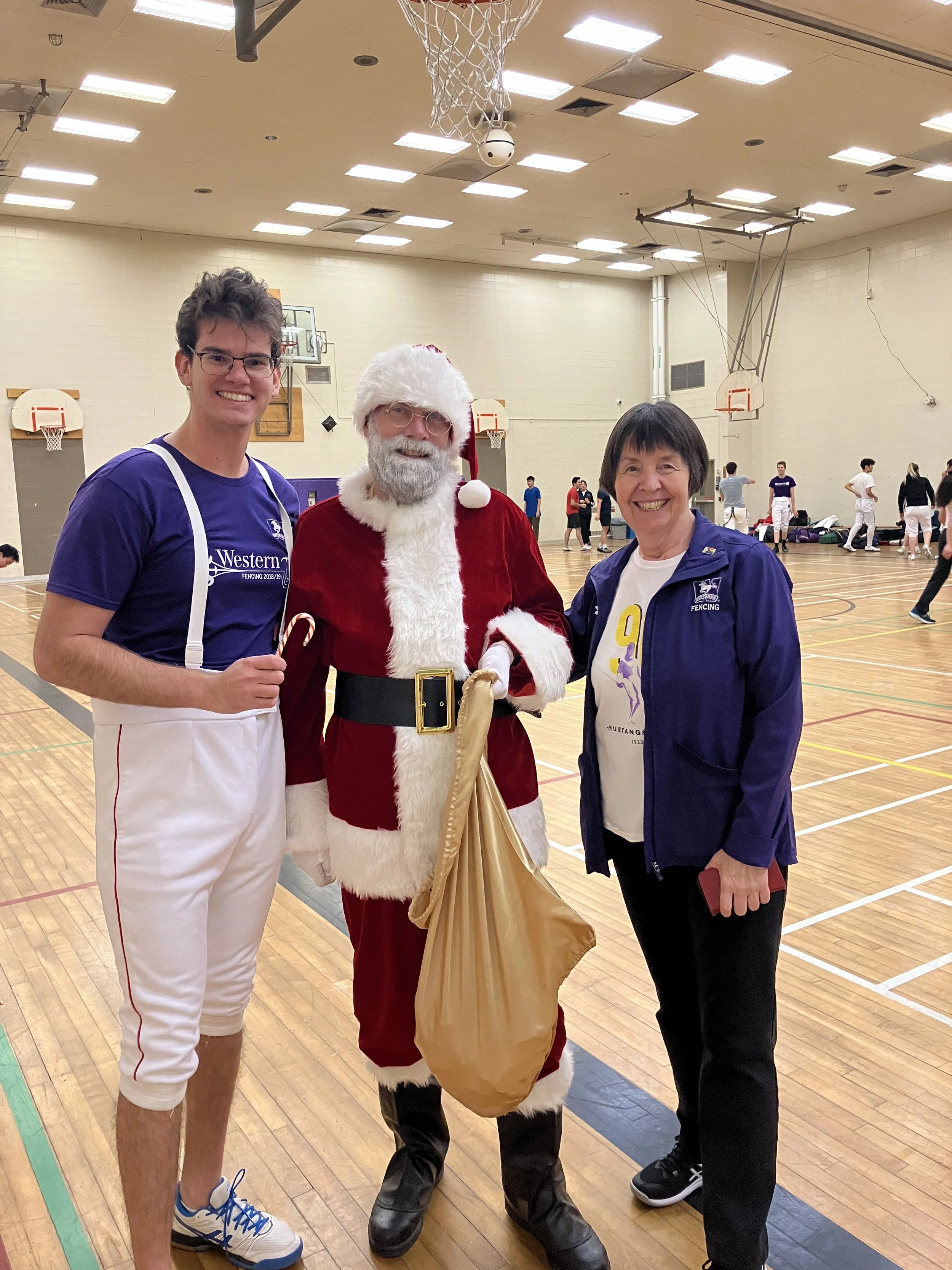 Alumni & Assistant Coach Sam Gerofsky with Santa and Carol.jpeg