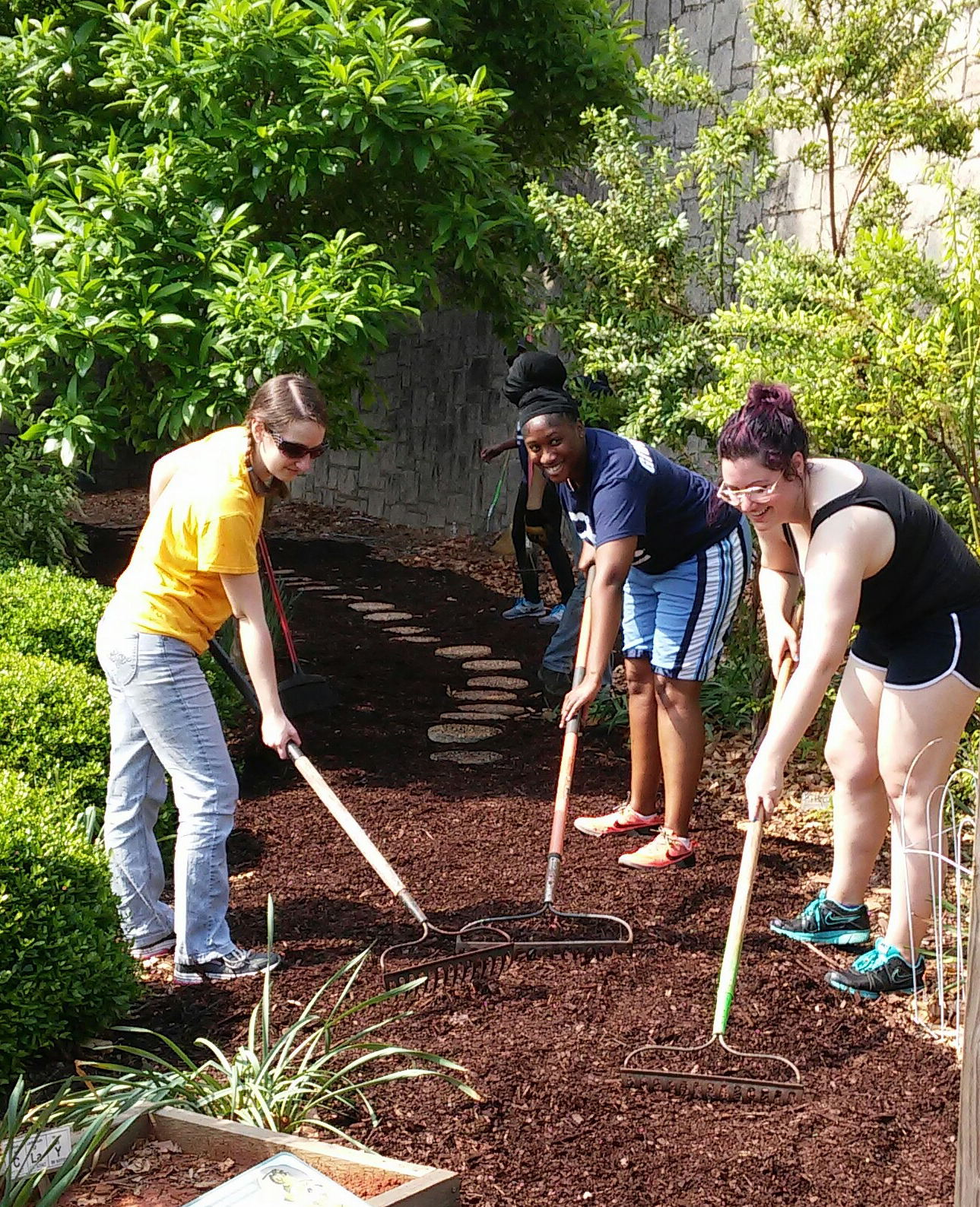 Becca Giuntoli (BCDB), Lisa Mills (IMP), and Stephanie Zimmer (BCDB) spread a new layer of mulch along the garden path at Fernbank Science Center.
