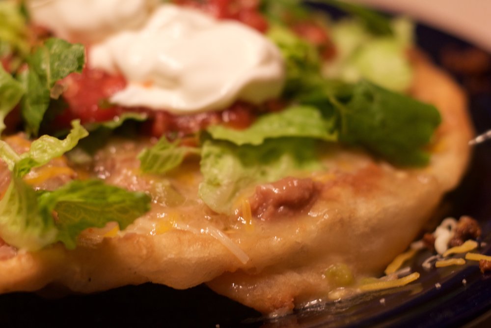  Top with refried beans, seasoned ground beef, green chile, lettuce, fresh salsa &amp; sour cream. 