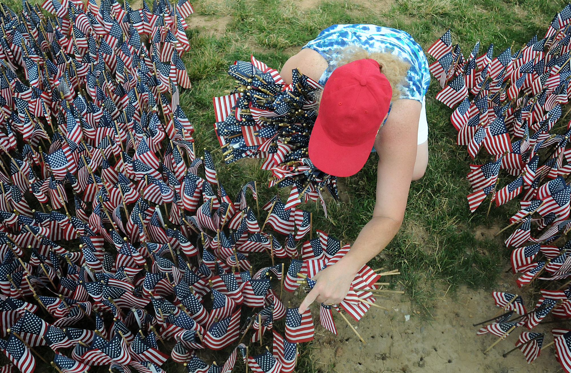  Donna Donohue, a friend of Treasurer Jesse Hill, unplants and collects flags following the Delaware Valley Vietnam Veterans 30th annual Donald W. Jones Flag Memorial for Flag Day at Falls Township Community Park. 65,000 flags are placed in the groun