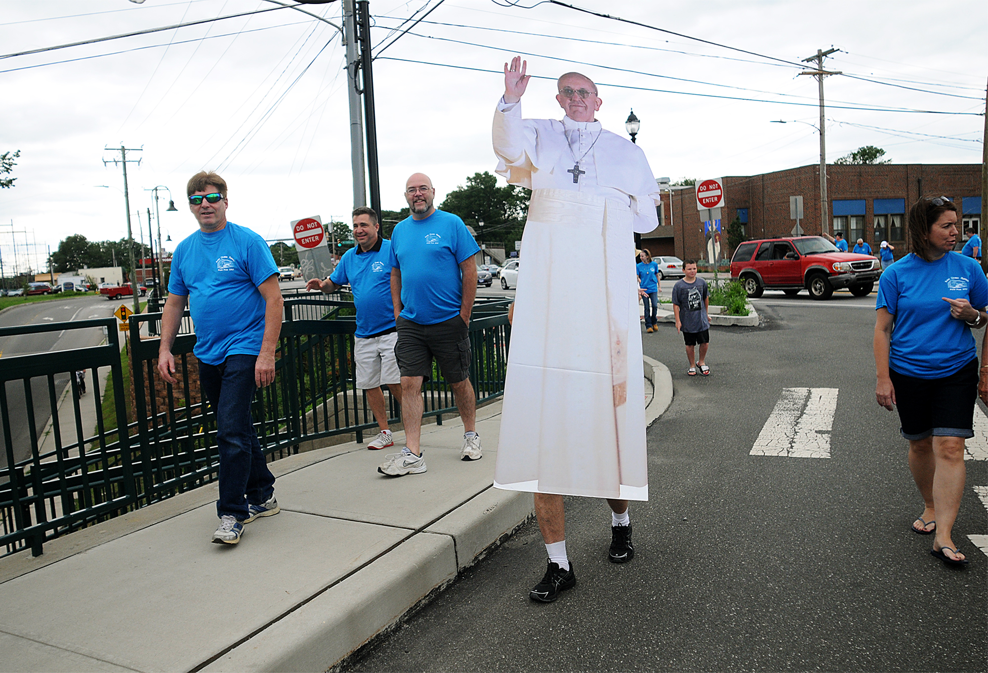  Parishioners from St. Thomas Aquinas Church in Croydon walk with fellow parishioner Tony Cinkutis, 75, as he carries a cardboard cutout of Pope Francis to the train station across the street from their church on Sunday, June 28, 2015. The Croydon tr