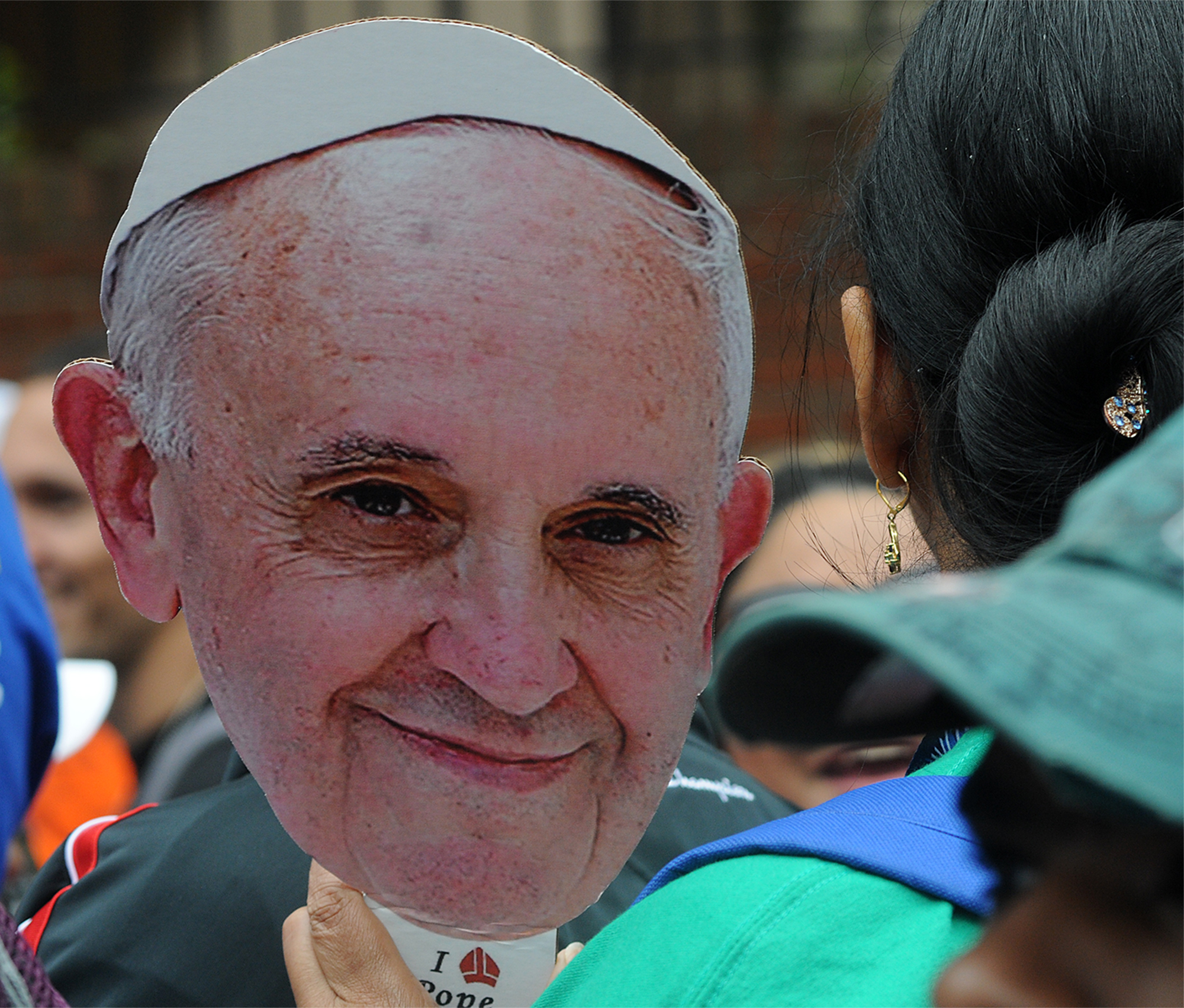  A woman holds a Pope Francis cardboard cutout while waiting to see Pope Francis' Mass on the Ben Franklin Parkway on September 27, 2015. Lines were multiple hours-long waits with no bathrooms or handicap entrances along the route. 