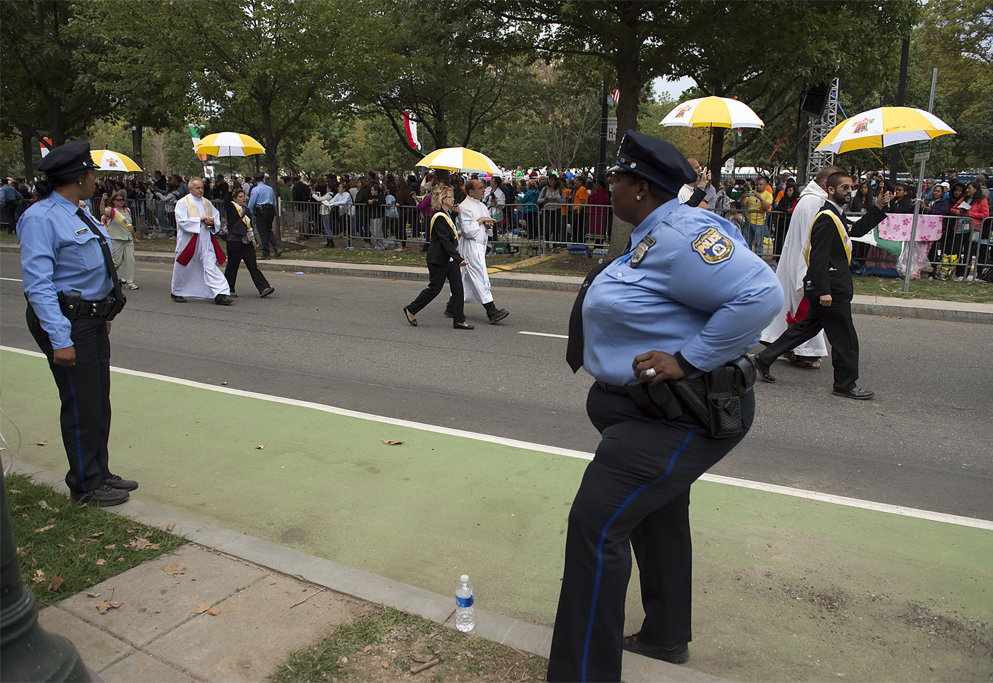  Philadelphia Police Officers watch as priests are escorted throughout the parkway to give communion as Pope Francis holds Mass on the Ben Franklin Parkway on September 27, 2015. 