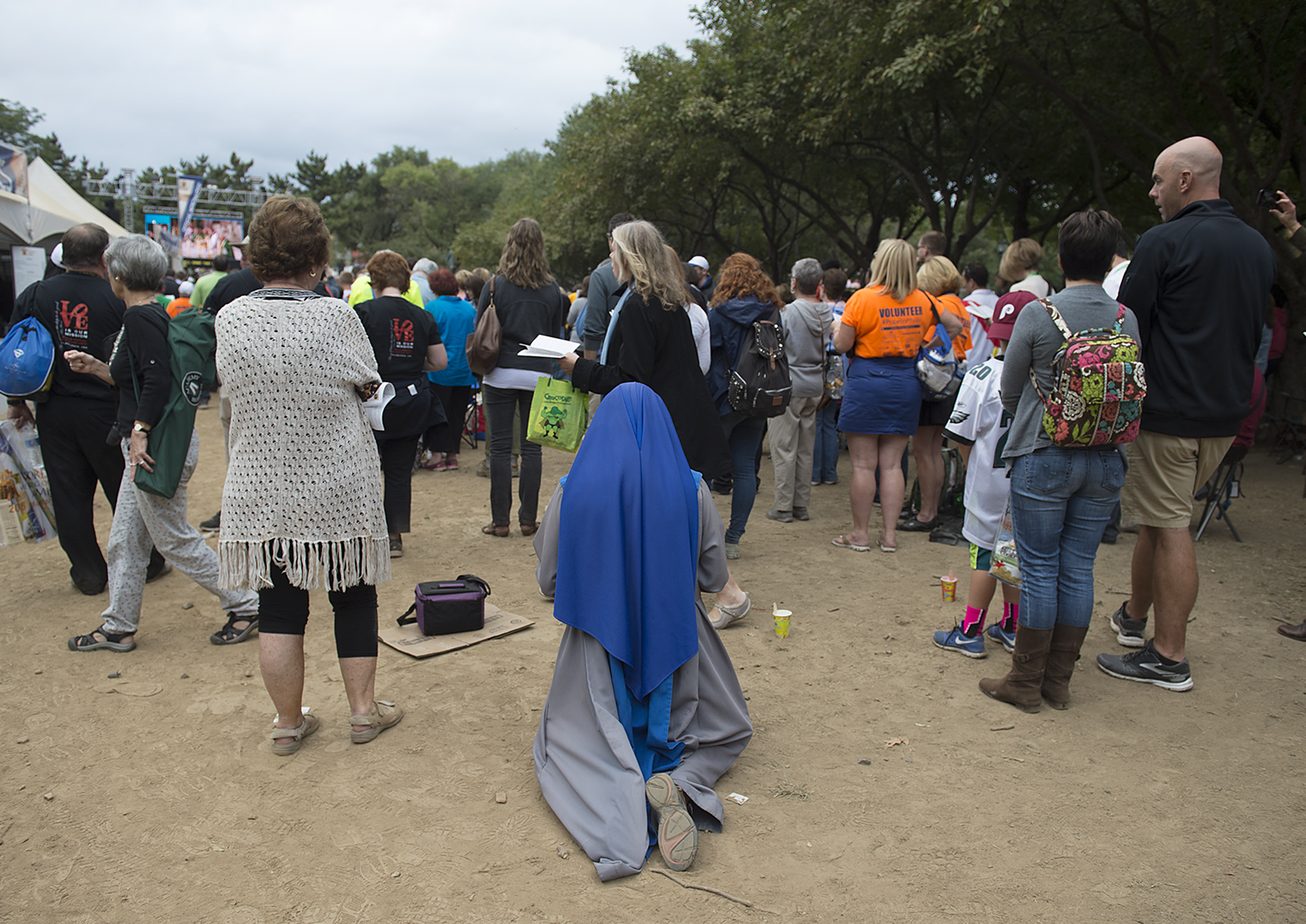  A woman kneels as she listens to Pope Francis holding Mass on the Ben Franklin Parkway on September 27, 2015. 